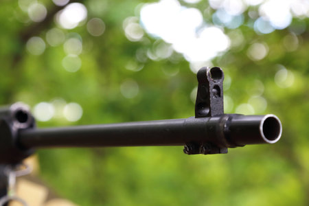 The background is military. Sighting the gun barrel at the target.