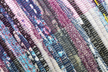 Needlework. Textile fabric background with diagonal lines. Rug for home made from colorful patches...