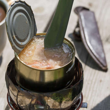 Camping gas stove portable for tourism travel and outdoor hiking. An open jar of boiling canned meat stewed meat warmed food, lunch in natureの写真素材