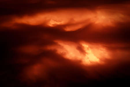 Fantastic concept mystical horror background from another planet from the paranormal world, fantasy style. Dramatic red black orange sky with scary hellish clouds and terrible shadows and fiery lightの写真素材