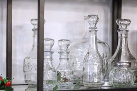 Various glass new empty decanters and cans for drinks and wine on shelf.の写真素材