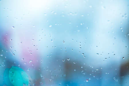 Abstract background with the texture of raindrops on the misted glass of a window with blue...