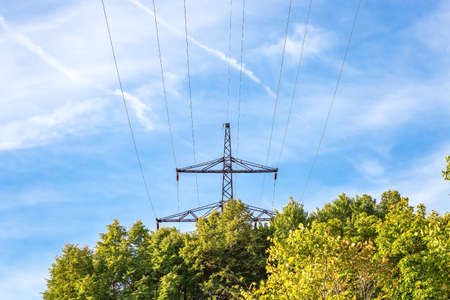 Energy and electricity industry, power lines, electrical equipment and high-voltage wires on the mountain near the forest against the background of nature and the sky.の写真素材