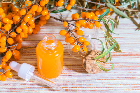 Hippophae sea buckthorn cosmetic oil in glass bottle with pipette, alternative herbal medicine and cosmetology.の写真素材