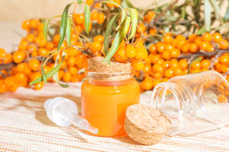 Hippophae cosmetic sea buckthorn oil in a glass bottle with a pipette on a background with a copy...
