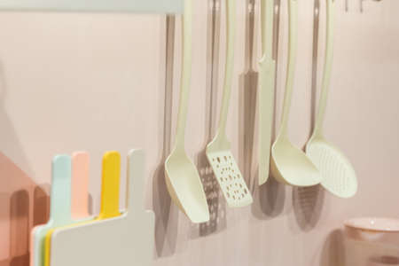 Kitchenware tools household goods plastic hang on the wall, kitchen interior in pastel trending colors.の写真素材
