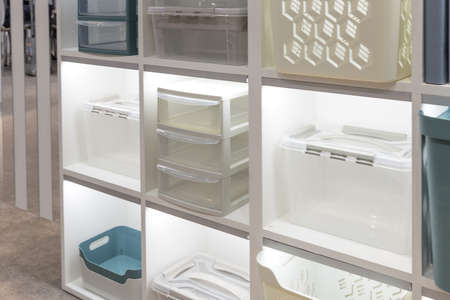 Plastic container boxes on a shelf on a rack for organizing home space and storing things, order and...