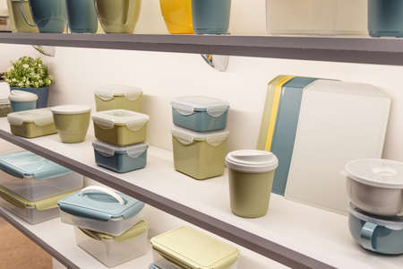 Industrial background with plastic products. Various containers for storing food on the shelf for...