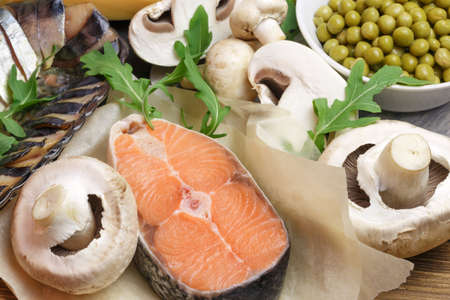 Healthy food, foods rich in vitamin D, omega 3 and protein, sea red salmon, smoked mackerel, mushrooms, champignons, canned green peas and arugula. Cooking recipe for the keto diet.の写真素材