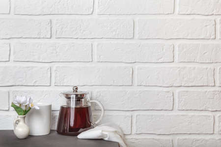 Kitchen cozy light background with copy space in loft style. Glass teapot with tea on the table. Tea break.の写真素材