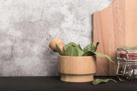 Spice bay leaf dried in a wooden mortar and pestle. Food kitchen background with copy space.