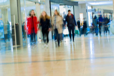 Abstract defocused motion blurred people in the shopping center, background.の写真素材