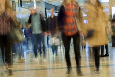 Abstract defocused motion blurred people in the shopping center, background.の写真素材