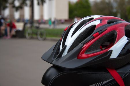 Cycling helmet on a bicycle seat closeup in summer parkの写真素材