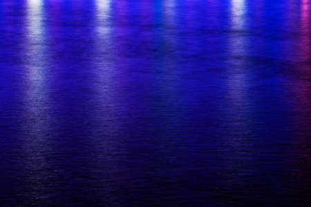 Background image of wavy ripples of water with bright blue reflectionsの写真素材