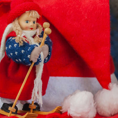Souvenir little cross country skier on a background of Santa Claus xmas red hats. With place for your text, for background use. Squareの写真素材