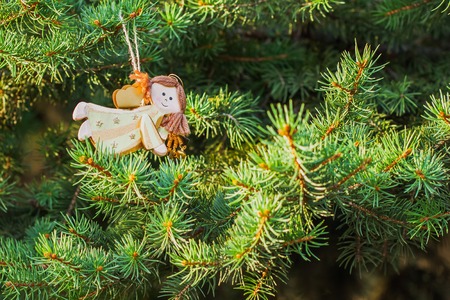 Figure of an angel on a green spruce Christmas tree decoration. For Christmas backgroundの写真素材