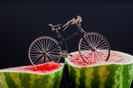 Sur. Vintage bicycle standing on top of a large cut in half scarlet ripe watermelonの写真素材