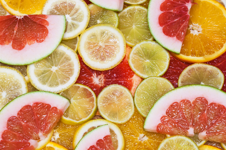 Colorful family of citrus fruits - slices of lemon, lime, grapefruit, orange, pomeloの写真素材