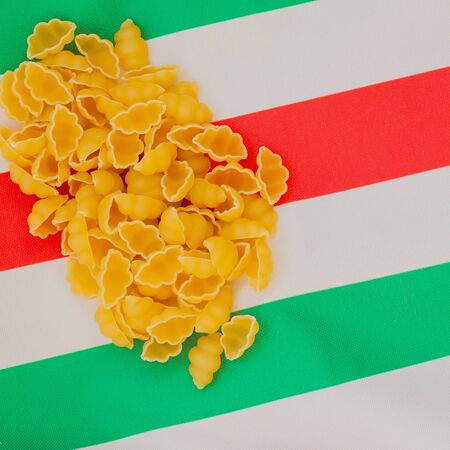 Dried Macaroni on the background of the Italian flag colors, place for writing text around itの写真素材