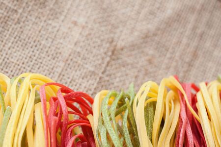 Dry pasta on a textile background from sackcloth. With place for your text,の写真素材
