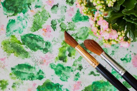 Brushes and hand made watercolor abstract floral background. Romantic concept of spring, lifestyle, hobbies. Top view. With place for your textの写真素材
