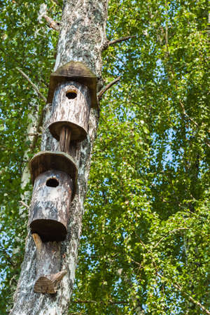 Two simple old birdhouse in a rustic style. Concept of the season, guest house, own housing, Dormitory, multi-storey building, townhouses, natural materials. Verticalの写真素材