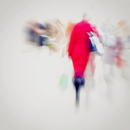 Abstract background. Intentional motion blur. Girl with handbag in red coat walking on the sidewalk. Concept of seasons, shopping, walking, lifestyle, modern city.の写真素材