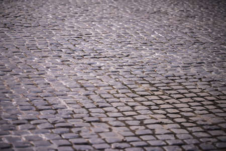 Cobblestone pavement, stone street pavement background with selective focus. Stone road texture,...