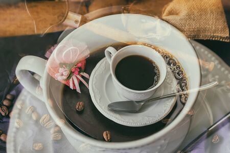 Double exposure of coffee cup, coffee beans, cup of hot coffee. Concept of Double coffee, hormone of happiness and good moodの写真素材