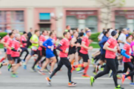 Large group of running athletes on street, city marathon, blur effect, unrecognizable faces. Sport, fitness, healthy lifestyle concept. For backdropの写真素材