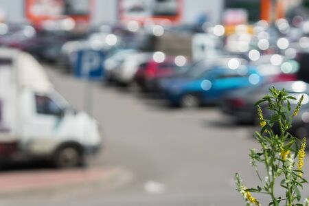 Blurred outdoor parking next to modern shopping mall, sunny summer day, season sales, for abstract backgroundの写真素材
