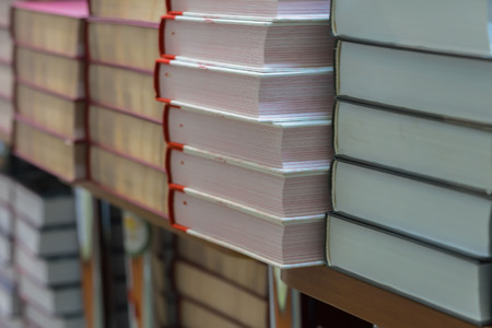 Many books, textbooks or fiction in rows lying on shelves in library or in modern urban bookshop. Self-study, educational, manuals, textbooks, school, study concept. Blurred abstract backgroundの写真素材