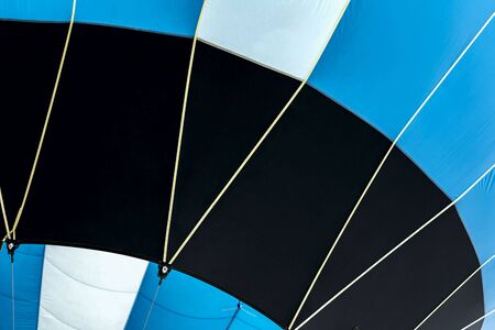 Bottom view of vivid hot air balloon, ready for flight close-up. Texture and pattern, blue, black and white colors. Modern background, place for your textの写真素材