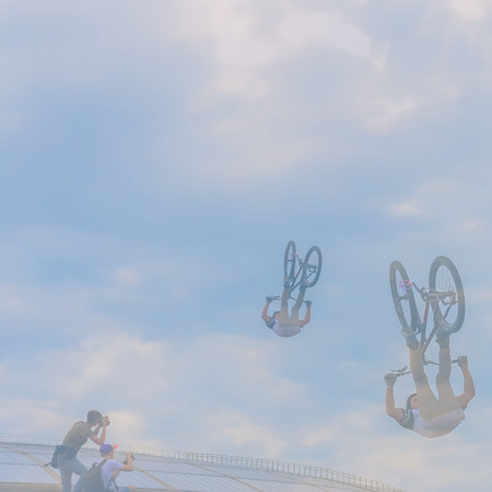 Silhouette of bike rider making jump. Risky moment falls into frames of photo correspondents. Lots of place for writing text around itの写真素材