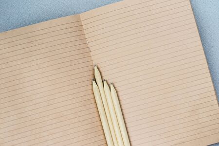 Open craft notebook and wooden Pencils, top view. Place for text, concept of starting school, back...