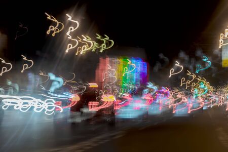 Very blurred background with lights of cars at dusk on the road of city. Transportation concept. Abstract blur bokehの写真素材