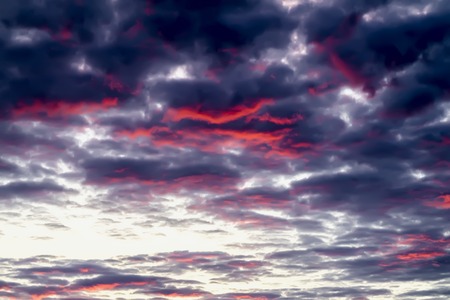Fantastic, but real amazing multicolor sunset with glowing vibrant clouds in dramatic colorful sky. Beautiful textured background with art shadesの写真素材