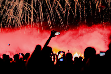 Blurred toned bright background with unrecognizable silhouettes of people back to us shooting shows...