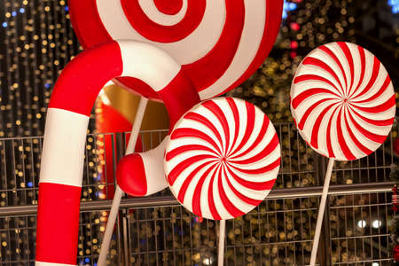 Close-up of piece of large red striped decorative Christmas lollipops. Festive abstract background,...