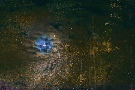 Abstract Natural scary Halloween backdrop, full moon, dark cloudy sky, bright super moon. Vintage background with cracks and scratchesの写真素材