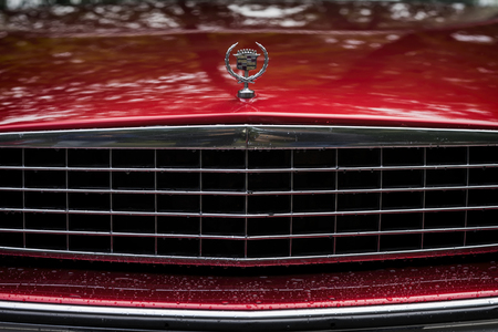 MOSCOW, RUSSIA - AUGUST 26, 2017: Close-up of red Cadillac car grill and logo, vintage car. Retro car show exhibion, motor vehicles festival. Rainy eveningのeditorial素材