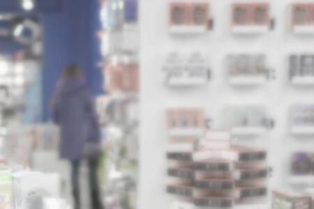 Blurred bookstore, girl. Many of interesting books. Education, school, study, reading fiction concept. Light backgroundの写真素材