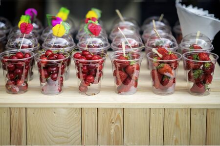 Fresh Berries and fruits in glasses, strawberries, cherries on wooden table. Concept of healthy food, detox, vitamins, dieting, vegetarianismの写真素材