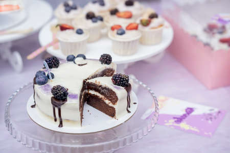 Delicious chocolate cake with cream and blackberries and Different appetizing confectionery, fresh...