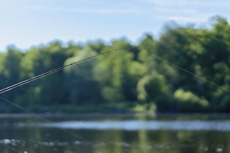 Summer landscape with fishing line on the background of lake, opposite shore, morning, selective...