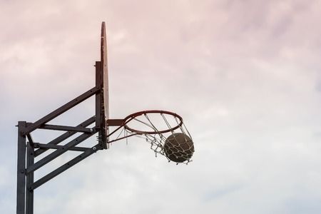 Street basketball game. Basketball shield, ball going through basket on background of sky. Concept of sport, hit accuracy, active lifestyle. copy spaceの写真素材