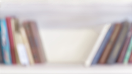 Row of colorful blank books. Blurred bookshelves of bookcase with books, studing, education. Modern...
