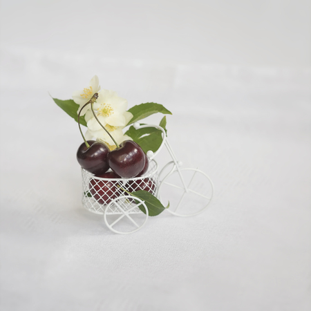 Miniature shopping cart, trolley with fresh cherry on light background wih copy space. Concept of healthy food, detox, vitamins, dietingの写真素材