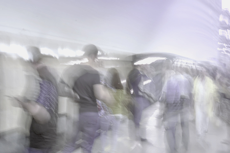 Abstract unrecognizable group of hurried passengers in subway station. Blurred motion background, violet shadesの写真素材